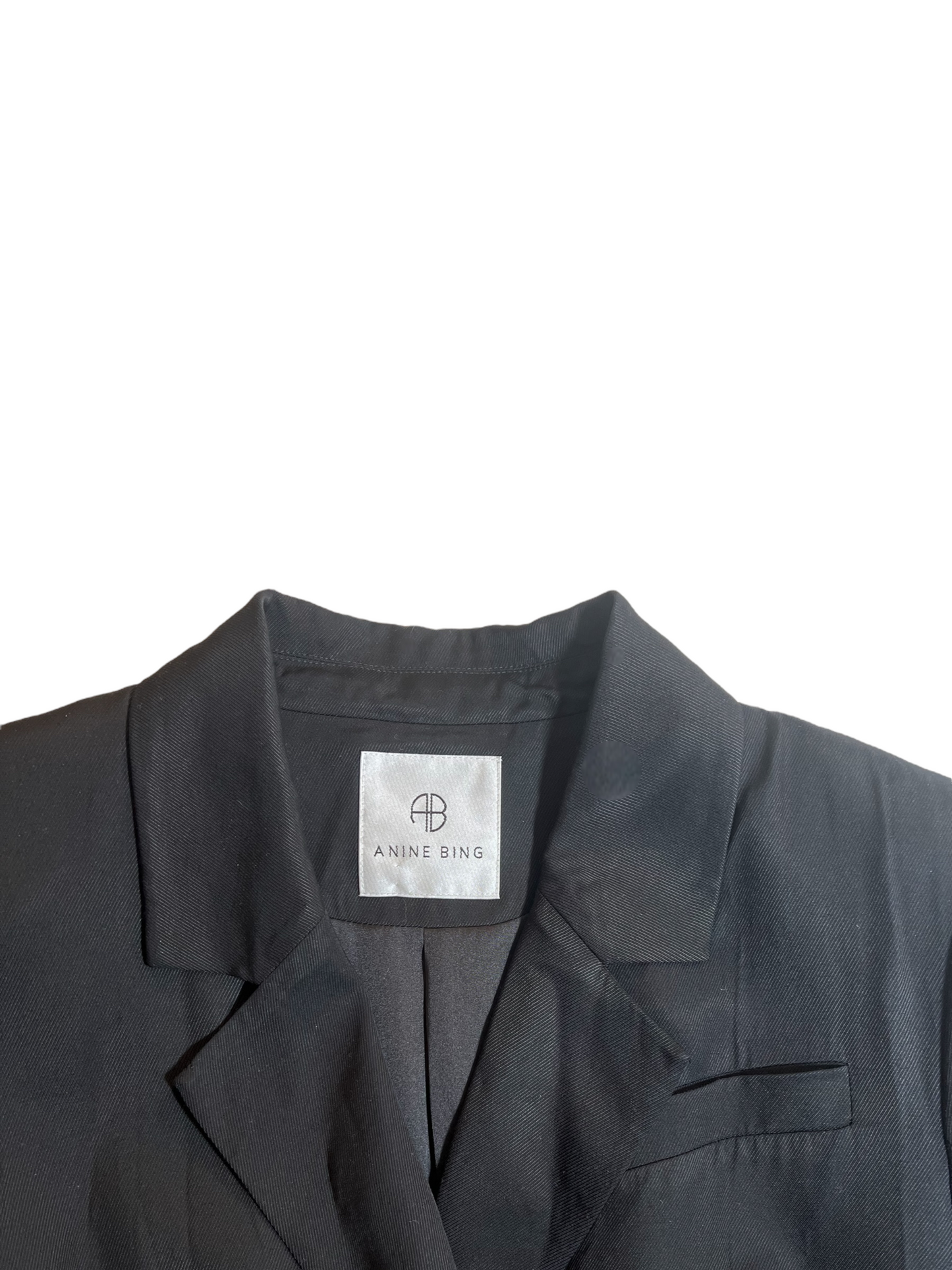 Black Annie Bing Womens Blazer. Double Breasted with 3/4 sleeves. Image shows a close up image of the Annie Bing Label.