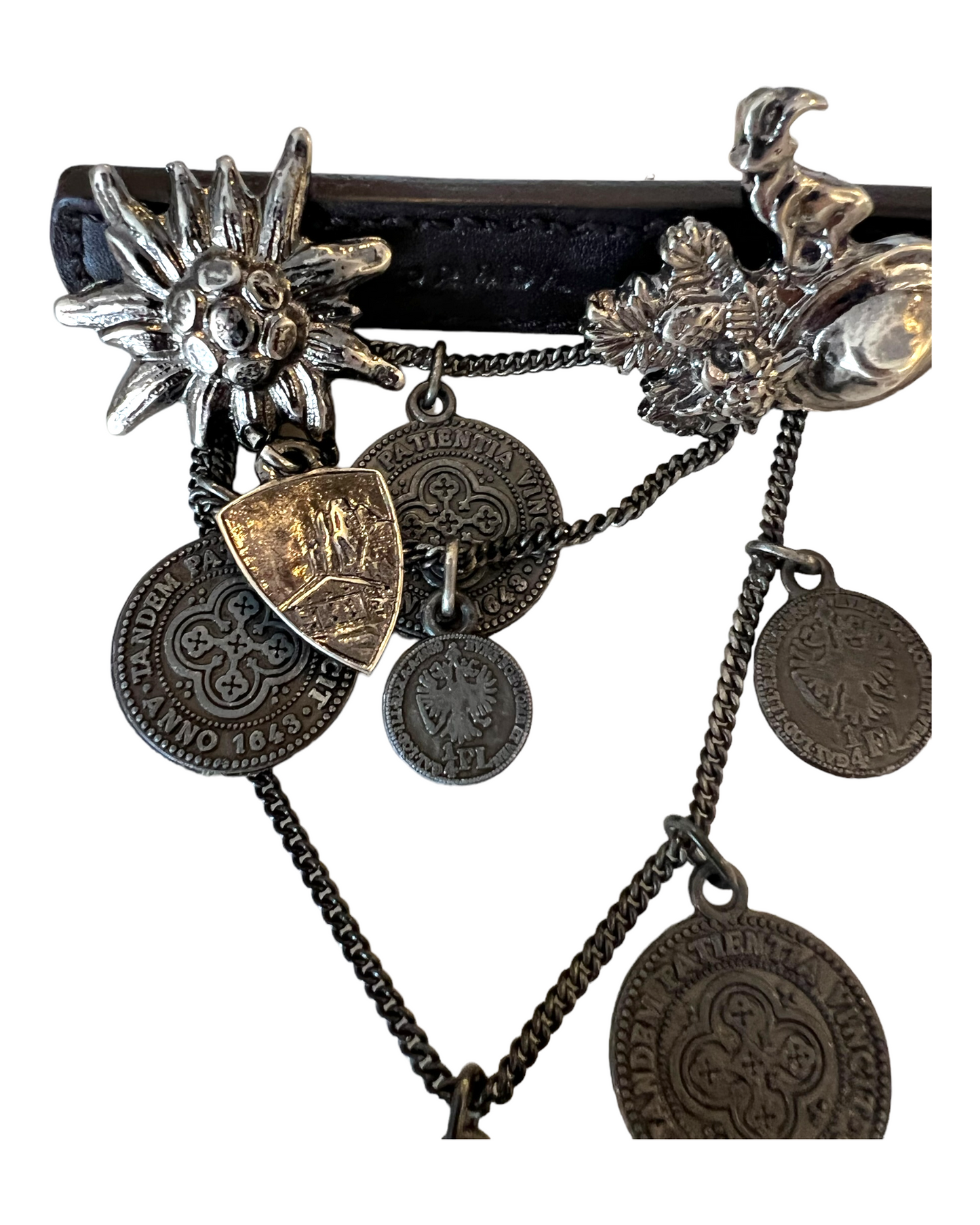 Vintage Prada Leather and Silver Cowboy Brooch. Charms include coins, a horseshoe, a goat, a cowboy hat, and a sunburst.