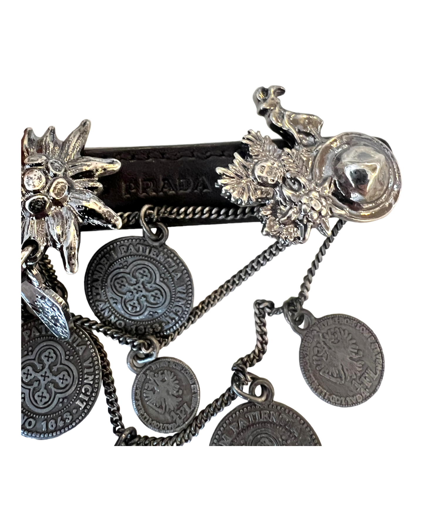 Vintage Prada Leather and Silver Cowboy Brooch. Charms include coins, a horseshoe, a goat, a cowboy hat, and a sunburst.