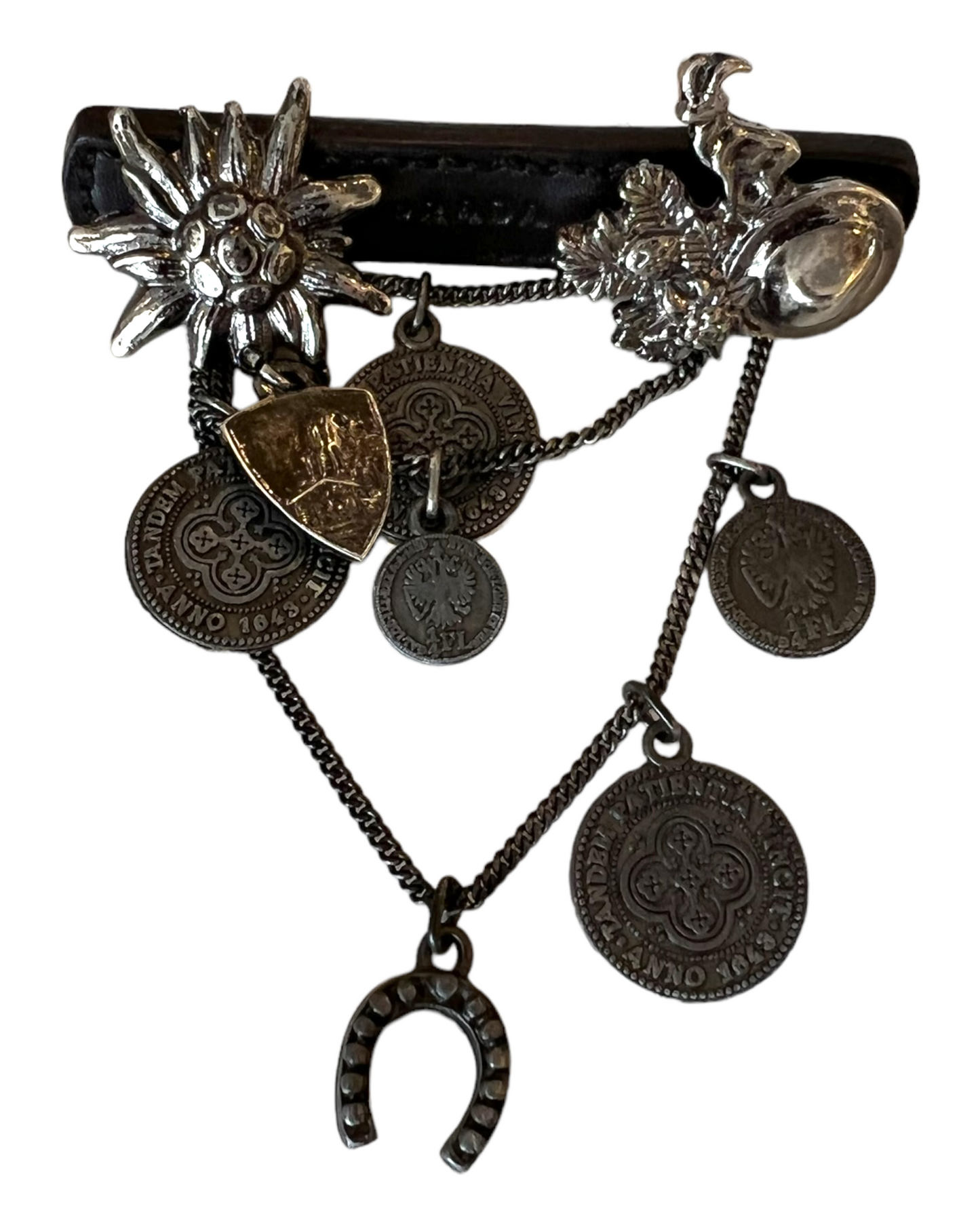 Vintage Prada Leather and Silver Cowboy Brooch. Charms include coins, a horseshoe, a goat, a cowboy hat, and a sunburst.