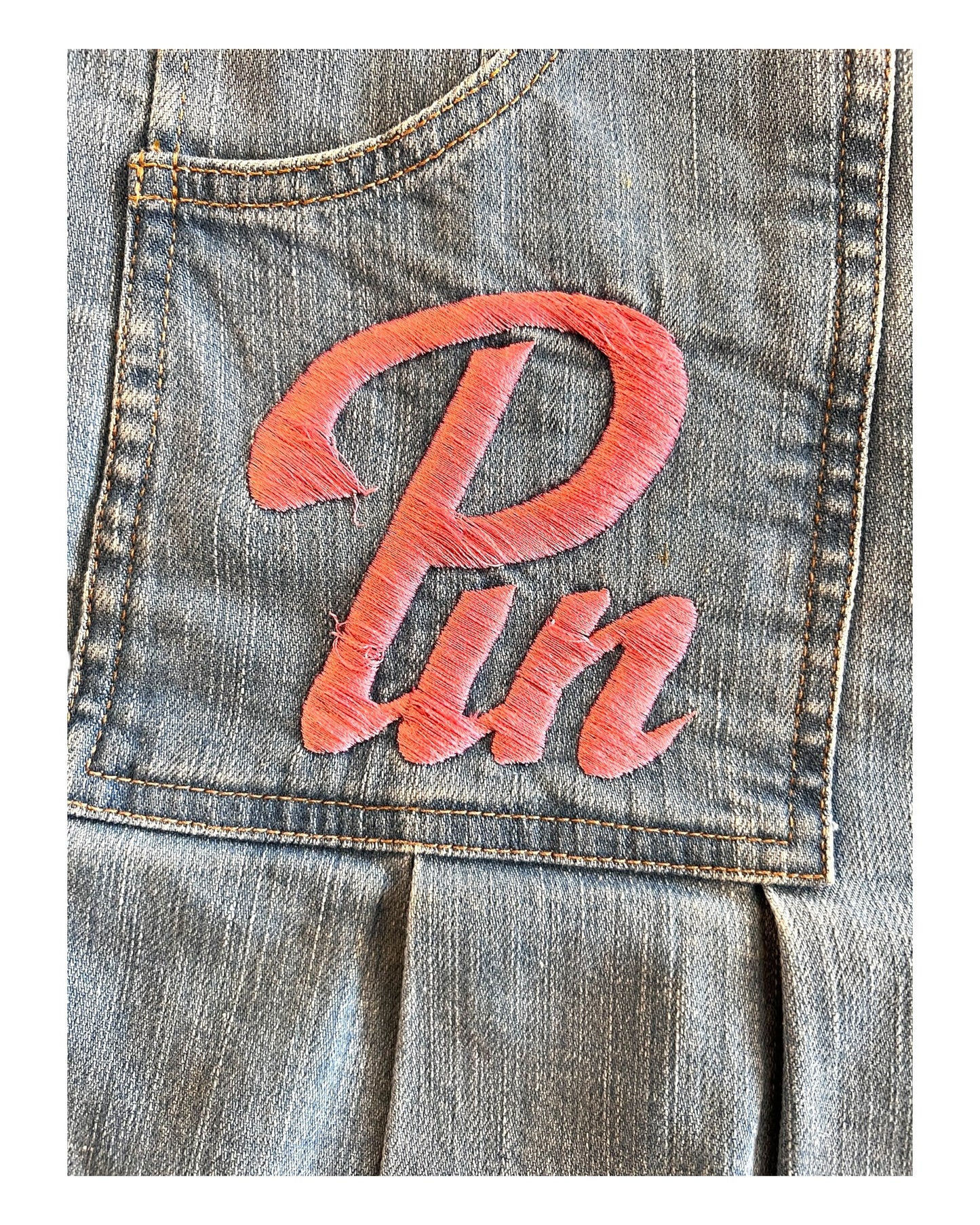 Vintage D&G "Pin Up" Mini Blue Denim Skirt. Back Pockets feature the phrase "Pin Up" written in pink embroidery. image depicts some loose threads on embroidery.