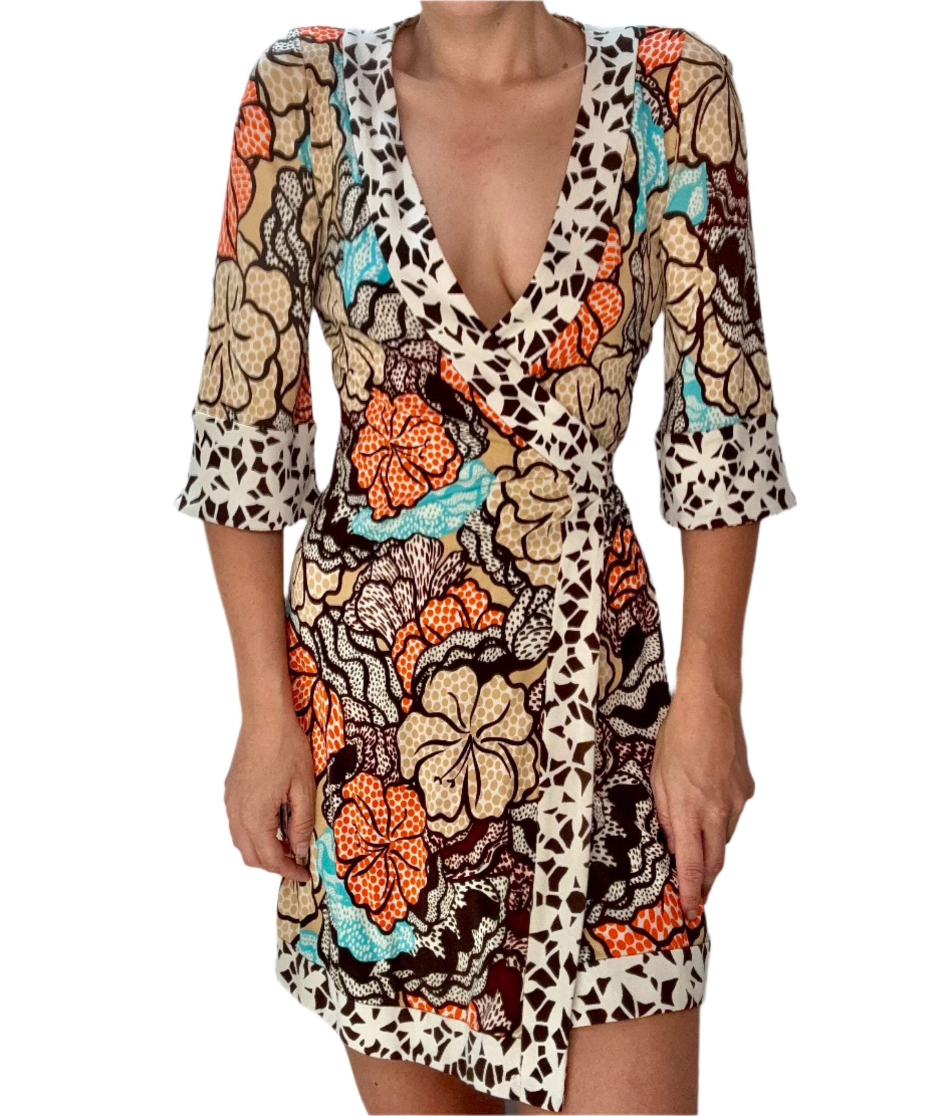 Woman wearing a colorful patterned dress against a plain background