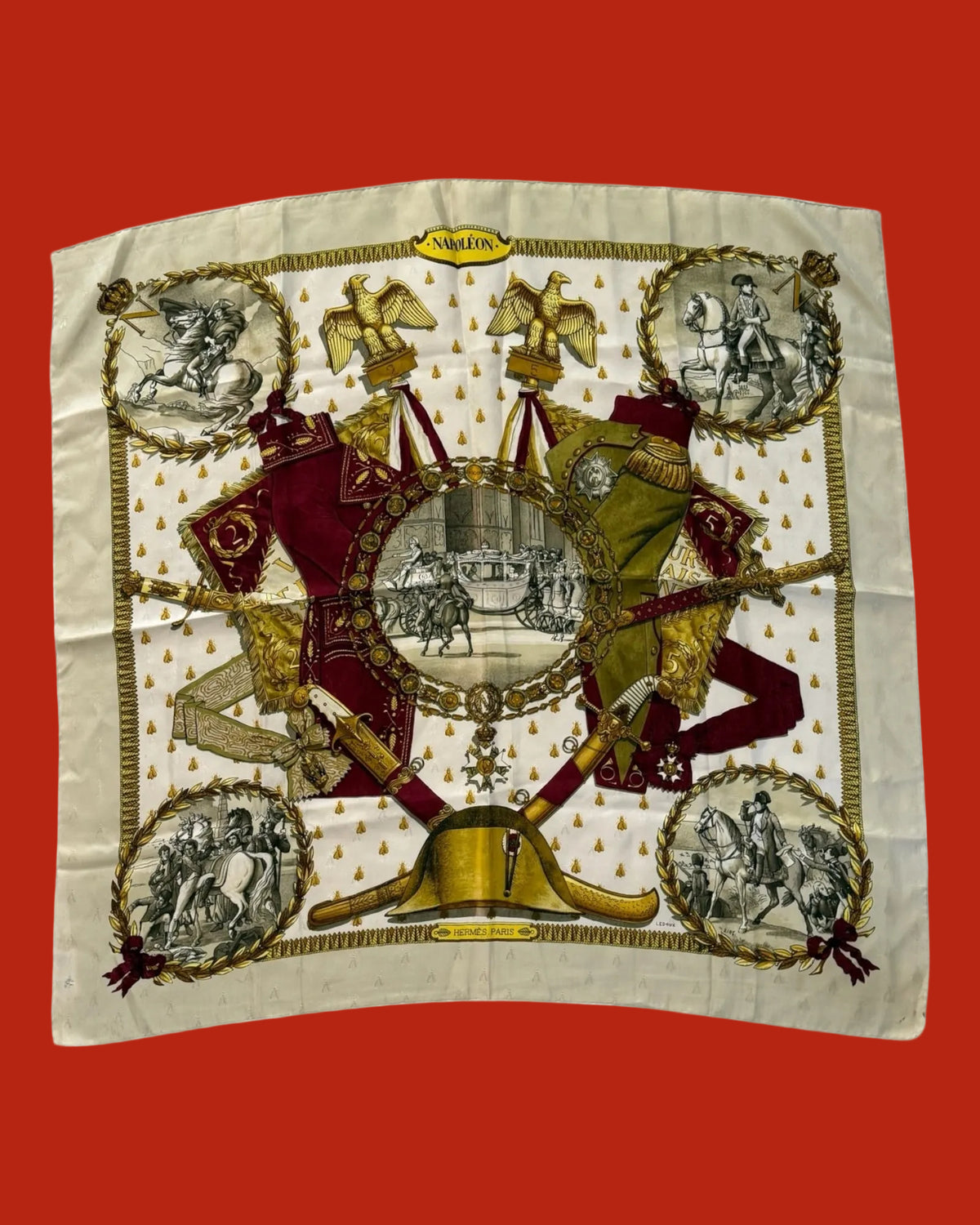 A square vintage silk scarf laid flat on a white background, featuring a detailed military-themed print with crossed swords, military uniforms, eagles, and circular historical scenes. The brand name 'NAPOLEON' is visible on a gold label at the top center.