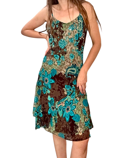Woman wearing a floral dress with blue and brown patterns on a white background
