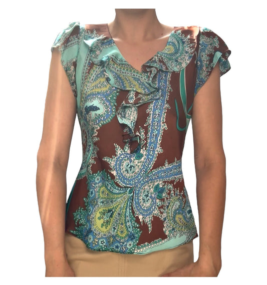 Colorful patterned top worn by a person on a white background