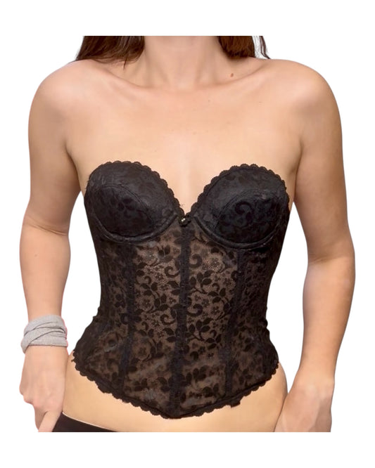 Black lace corset worn by a person on a white background
