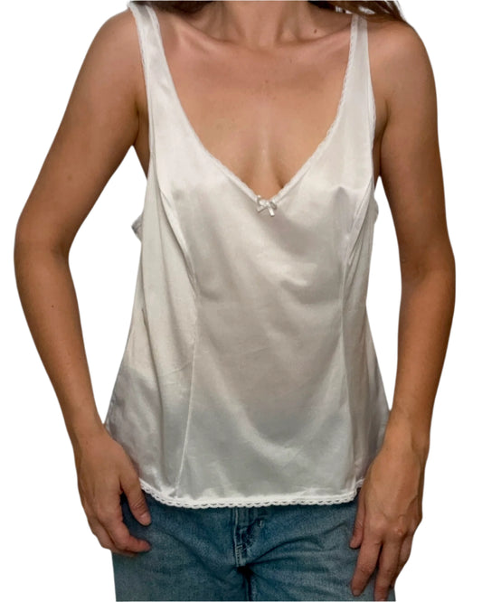 White satin camisole worn over a plain background
