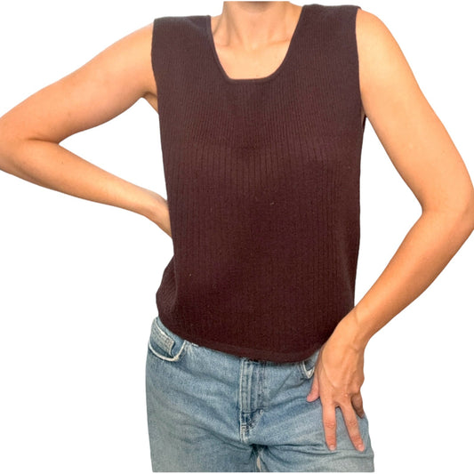 Person wearing a brown sleeveless top and blue jeans on a white background